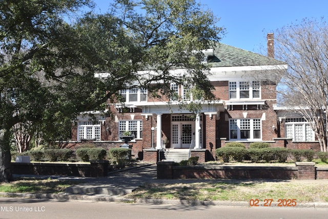 view of front of house with brick siding and french doors