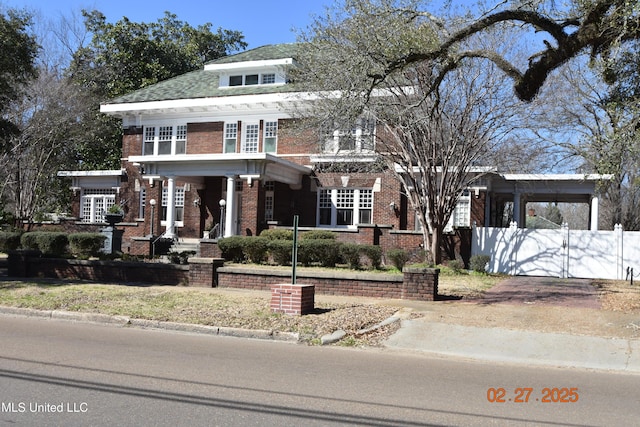 view of front of home with brick siding and fence