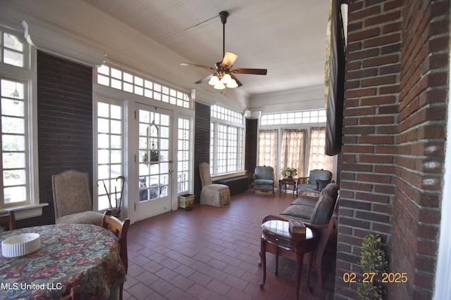 interior space featuring brick floor, plenty of natural light, ornamental molding, and a ceiling fan