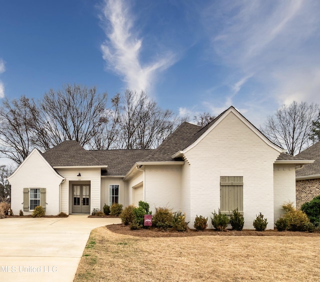 view of front of house with a garage, a front yard, and french doors