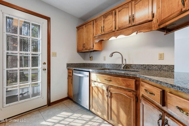 7300 Frank Snell Rd, Moss Point, MS 39562 - kitchen featuring dishwasher, a sink, brown cabinets, light tile patterned flooring, and baseboards