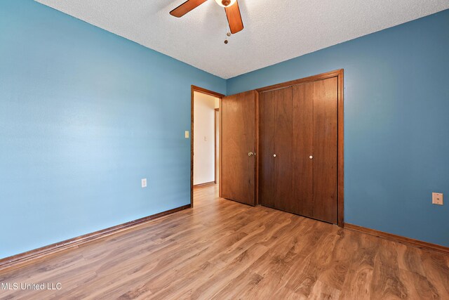 7300 Frank Snell Rd, Moss Point, MS 39562 - unfurnished bedroom with light wood-style flooring, a closet, baseboards, a textured ceiling, and ceiling fan