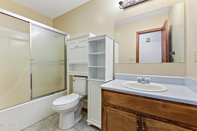 7300 Frank Snell Rd, Moss Point, MS 39562 - full bathroom featuring vanity, toilet, shower / bath combination with glass door, a textured ceiling, and tile patterned floors