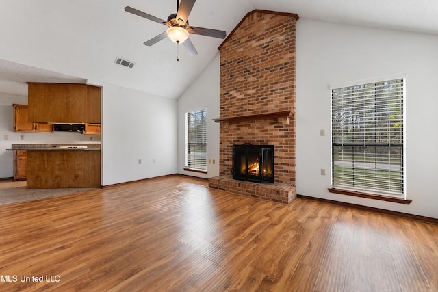7300 Frank Snell Rd, Moss Point, MS 39562 - unfurnished living room featuring high vaulted ceiling, a ceiling fan, light wood-style flooring, and a brick fireplace
