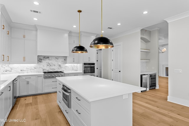 kitchen with decorative backsplash, wine cooler, white cabinets, appliances with stainless steel finishes, and light hardwood / wood-style floors