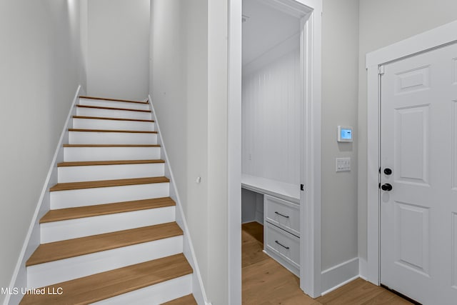 stairway with built in desk and hardwood / wood-style floors