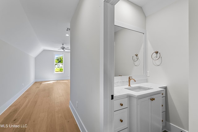 bathroom with vanity, ceiling fan, wood-type flooring, and vaulted ceiling