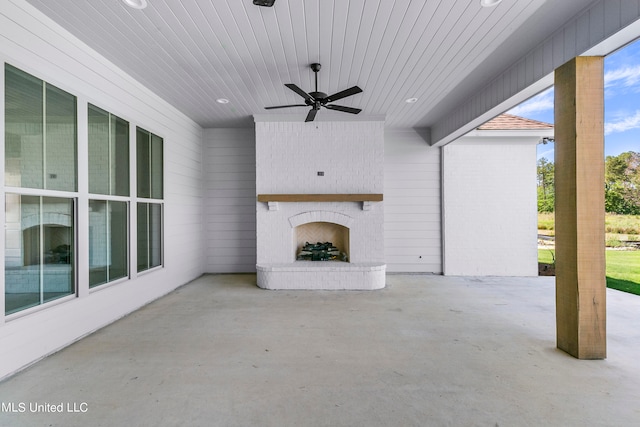 view of patio featuring an outdoor brick fireplace and ceiling fan