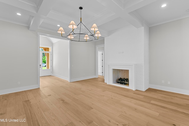 unfurnished living room featuring light wood-type flooring, coffered ceiling, beam ceiling, ornamental molding, and a chandelier