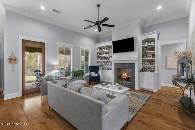 living room featuring ornamental molding, dark hardwood / wood-style floors, built in features, and ceiling fan