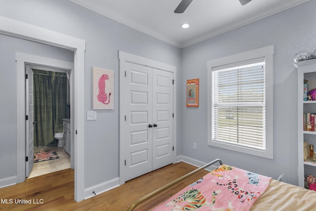 bedroom featuring hardwood / wood-style flooring, ceiling fan, crown molding, and a closet