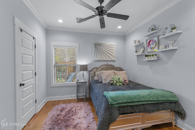 bedroom featuring hardwood / wood-style floors, crown molding, and ceiling fan