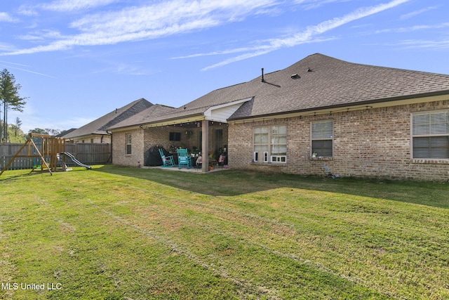 back of property with a playground, a patio area, and a lawn