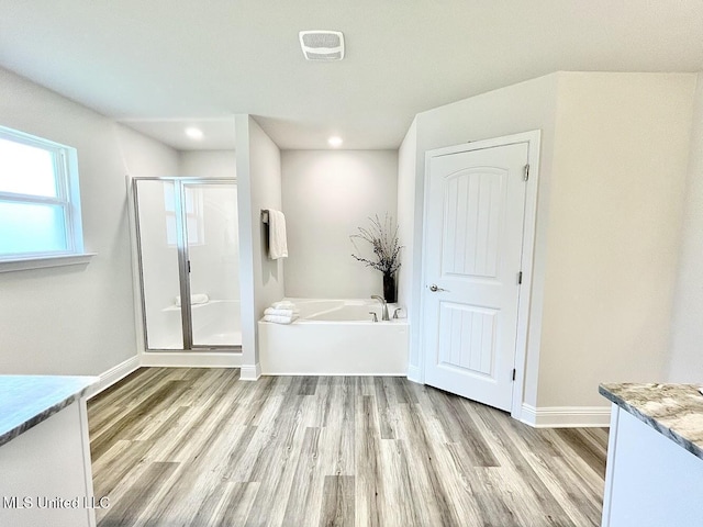 15681 Perdido Dr, Gulfport, MS 39503 - bathroom with a shower stall, wood finished floors, a bath, vanity, and recessed lighting