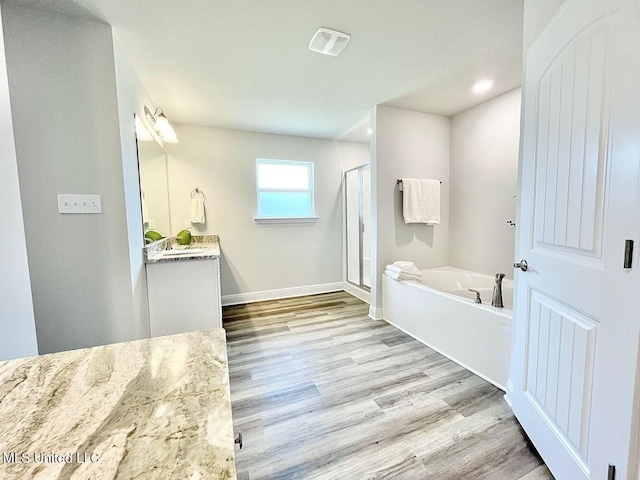 15681 Perdido Dr, Gulfport, MS 39503 - full bathroom with vanity, a bath, wood finished floors, a stall shower, and baseboards