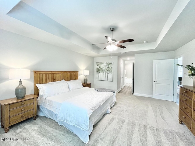 15681 Perdido Dr, Gulfport, MS 39503 - bedroom featuring light carpet, a tray ceiling, baseboards, and a ceiling fan