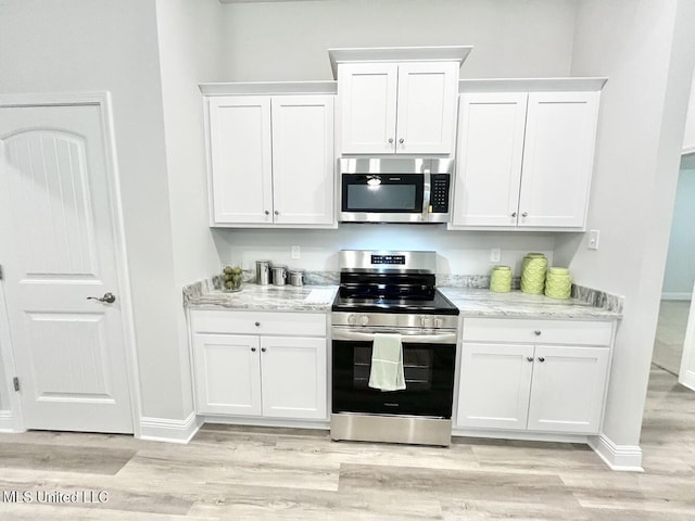 15681 Perdido Dr, Gulfport, MS 39503 - kitchen with stainless steel appliances, white cabinetry, light wood finished floors, and light stone counters