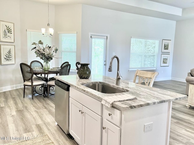 15681 Perdido Dr, Gulfport, MS 39503 - kitchen with a sink, stainless steel dishwasher, a kitchen island with sink, light wood-style flooring, and light stone counters