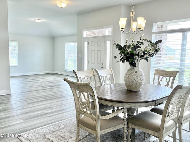 15681 Perdido Dr, Gulfport, MS 39503 - dining space with a chandelier, light wood-type flooring, baseboards, plenty of natural light, and lofted ceiling