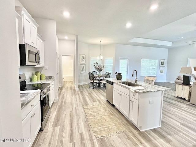 15681 Perdido Dr, Gulfport, MS 39503 - kitchen featuring appliances with stainless steel finishes, a sink, light wood finished floors, recessed lighting, and white cabinetry