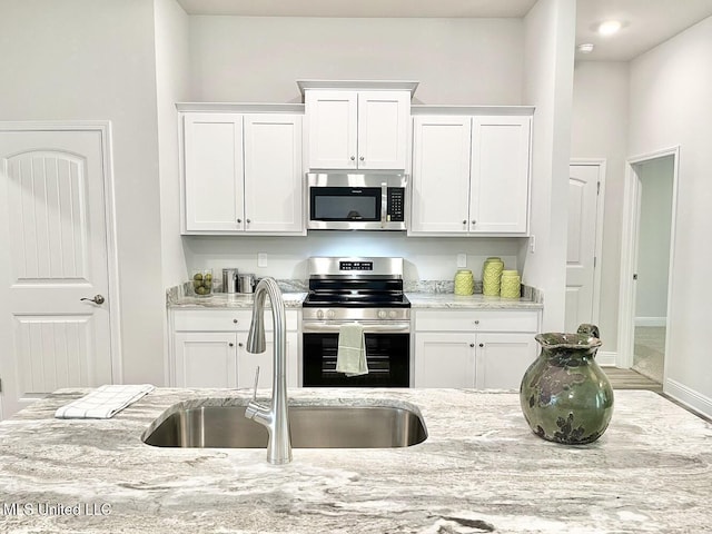 15681 Perdido Dr, Gulfport, MS 39503 - kitchen with stainless steel appliances, a sink, and white cabinets