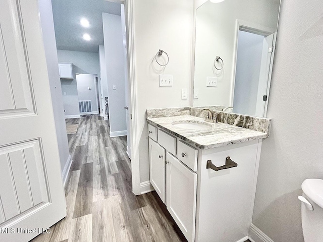 15681 Perdido Dr, Gulfport, MS 39503 - bathroom with wood finished floors, vanity, baseboards, and toilet