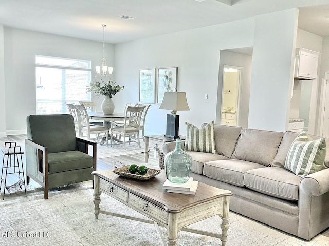 15681 Perdido Dr, Gulfport, MS 39503 - living area with light wood-type flooring, a chandelier, and baseboards