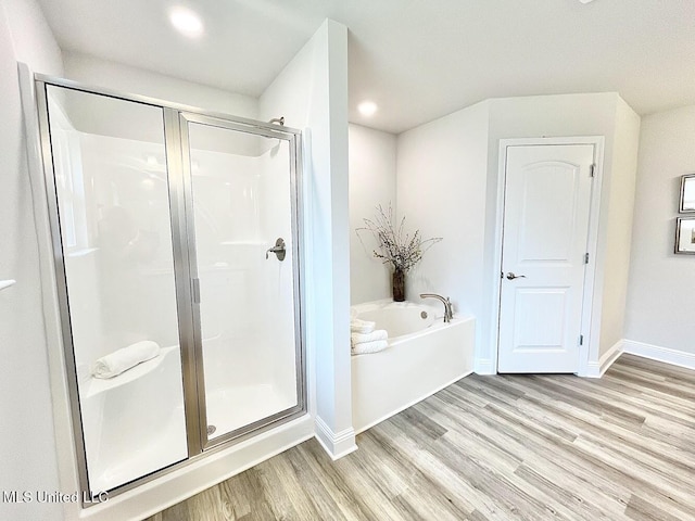 15681 Perdido Dr, Gulfport, MS 39503 - full bathroom featuring wood finished floors, a stall shower, a bath, baseboards, and recessed lighting
