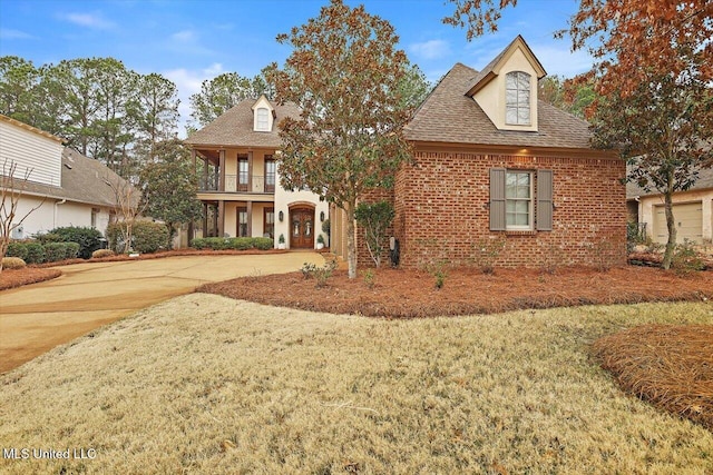 view of front facade featuring a balcony and a front lawn