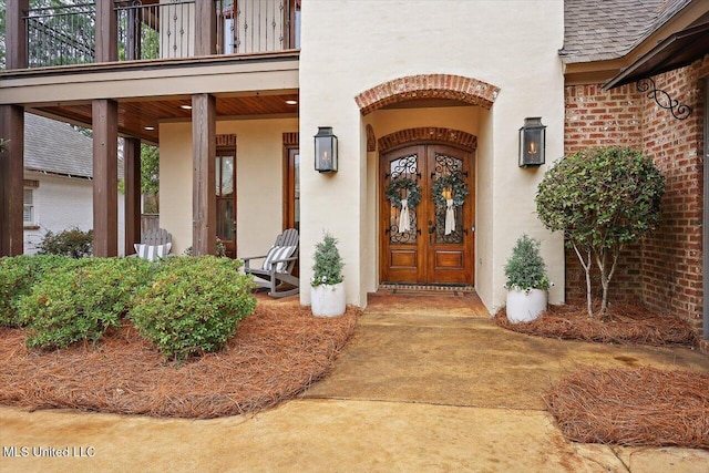 doorway to property with a balcony and french doors