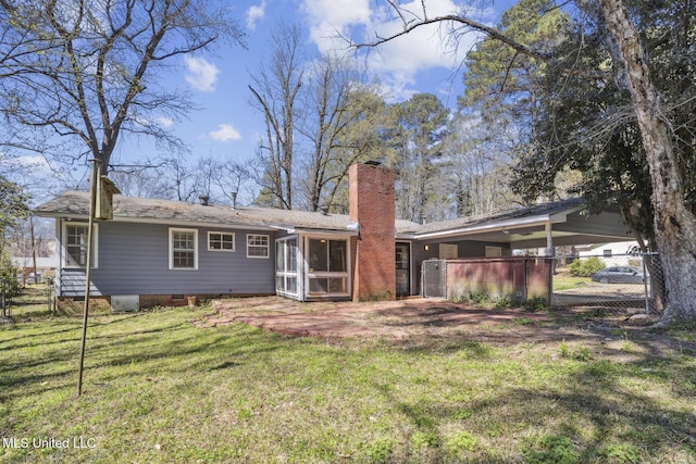 5360 Wayneland Dr, Jackson, MS 39211 - rear view of property featuring fence, a yard, a sunroom, a chimney, and a carport