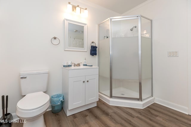 bathroom with vanity, wood finished floors, a shower stall, and ornamental molding