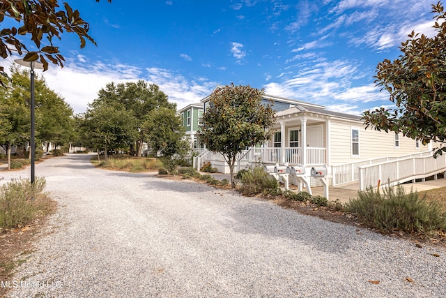 view of front of property featuring a porch and gravel driveway