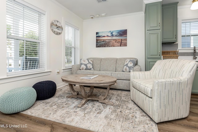 living room featuring crown molding, visible vents, and wood finished floors