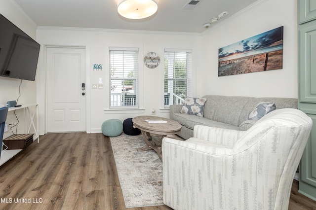 living room with visible vents, wood finished floors, and ornamental molding
