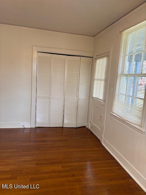 301 Hampton St, Indianola, MS 38751 - unfurnished bedroom featuring dark wood-style floors, a closet, and baseboards