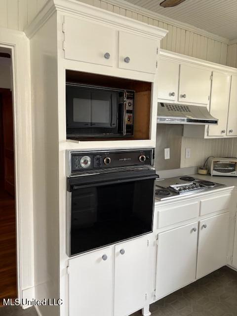 301 Hampton St, Indianola, MS 38751 - kitchen with white cabinetry, black appliances, under cabinet range hood, light countertops, and a toaster