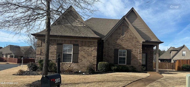 view of front of property featuring fence and roof with shingles