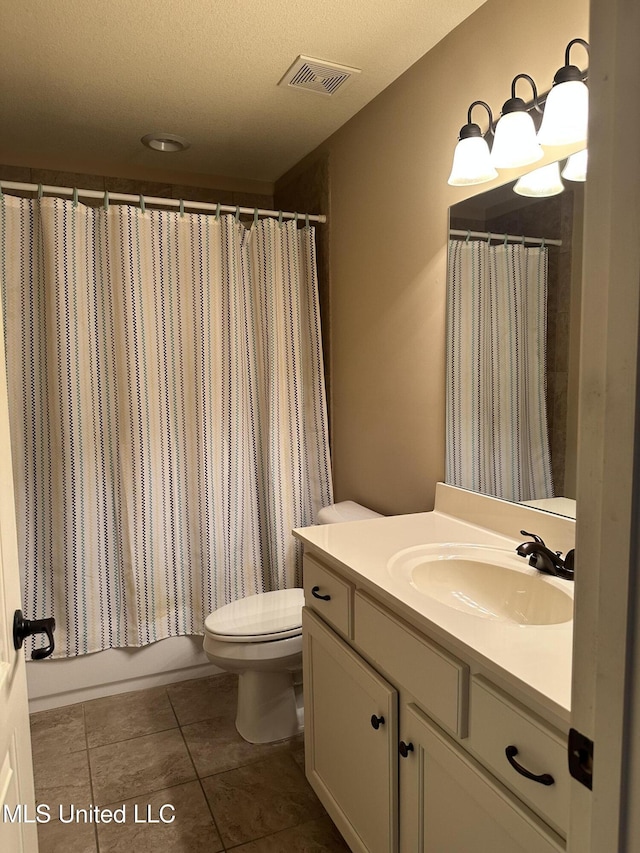 bathroom with visible vents, toilet, a textured ceiling, vanity, and tile patterned floors