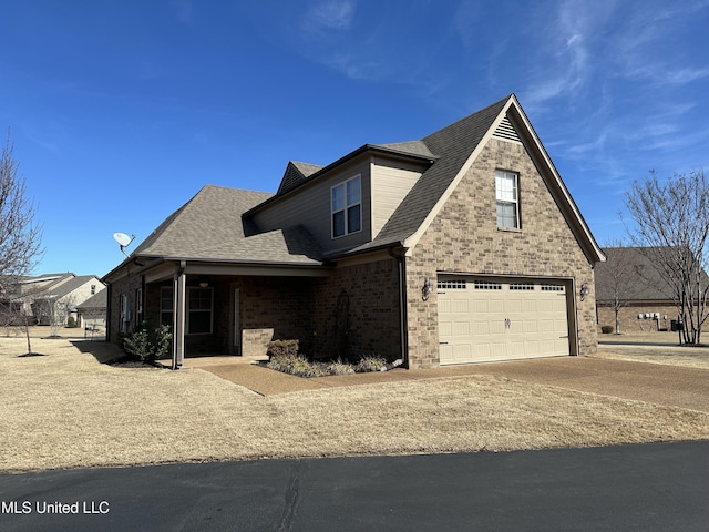 traditional home with an attached garage, roof with shingles, and brick siding