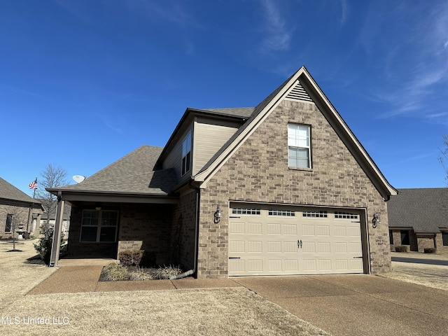 view of front of home with a garage, concrete driveway, and roof with shingles