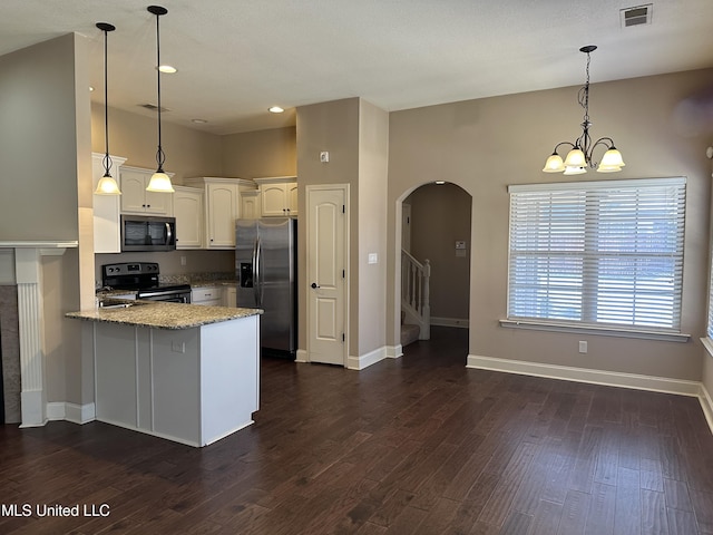 kitchen featuring dark wood-style flooring, visible vents, appliances with stainless steel finishes, white cabinets, and a peninsula