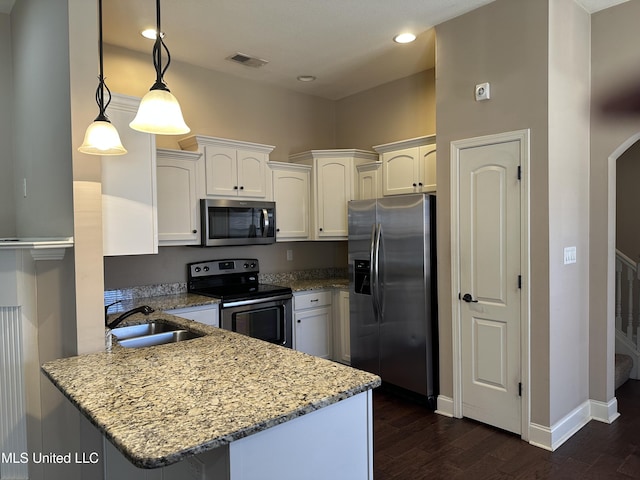 kitchen with arched walkways, stainless steel appliances, a peninsula, a sink, and visible vents