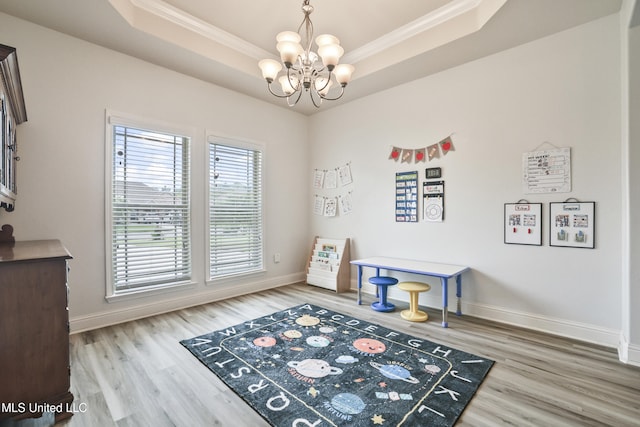 13111 Hawthorn Dr, Biloxi, MS 39532 - rec room featuring a raised ceiling, crown molding, a chandelier, wood finished floors, and baseboards