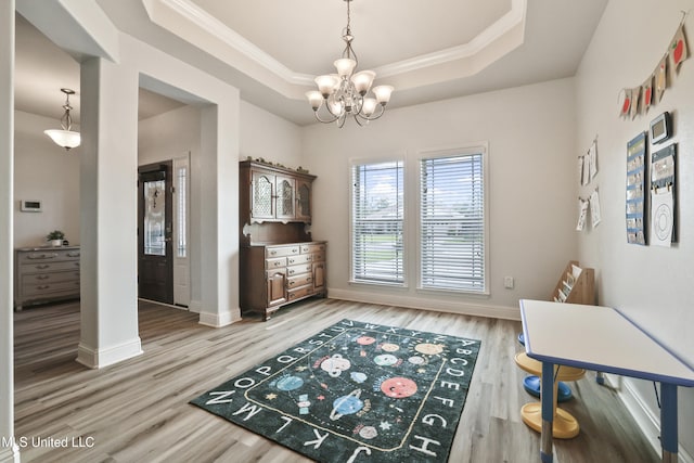 13111 Hawthorn Dr, Biloxi, MS 39532 - dining space featuring a raised ceiling, crown molding, a chandelier, baseboards, and light wood finished floors