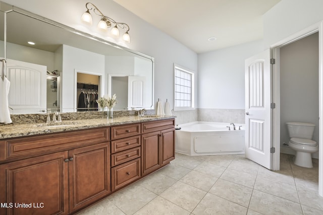 13111 Hawthorn Dr, Biloxi, MS 39532 - bathroom featuring double vanity, a garden tub, tile patterned floors, toilet, and a walk in closet