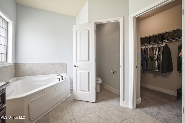 13111 Hawthorn Dr, Biloxi, MS 39532 - bathroom featuring a bath, toilet, a walk in closet, tile patterned flooring, and baseboards