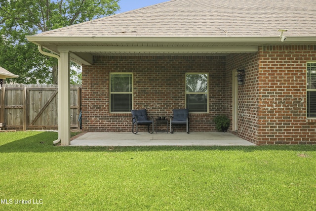 13111 Hawthorn Dr, Biloxi, MS 39532 - back of property featuring a shingled roof, brick siding, and a patio