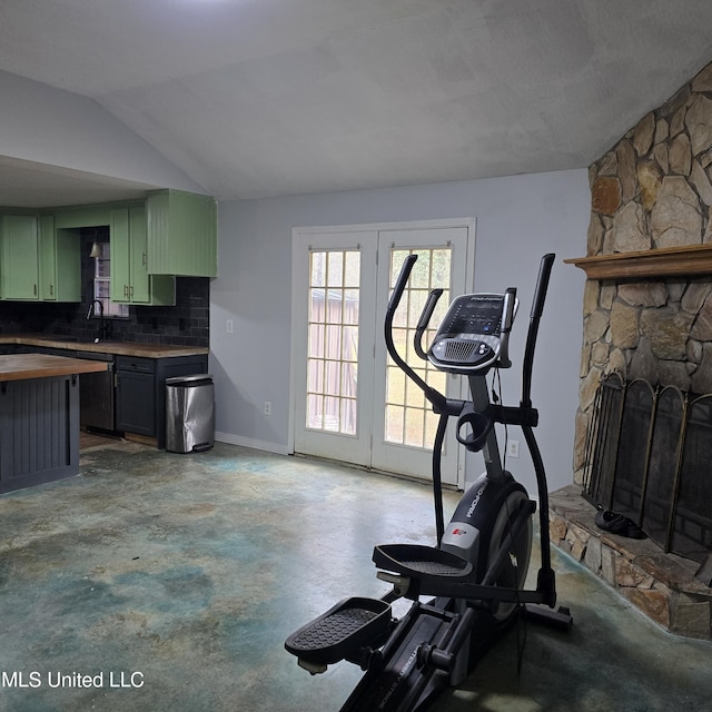 workout area featuring lofted ceiling and a fireplace