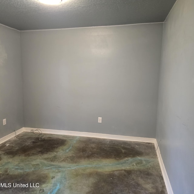 unfurnished room featuring concrete flooring and a textured ceiling